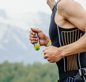 Corredor durante prova de corrida de rua consumindo gel energético de carboidrato no percurso